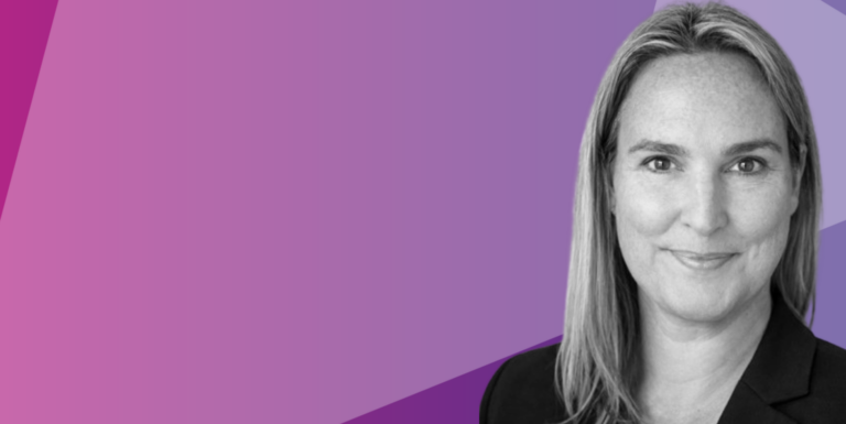 A smiling woman with long fair hair and a dark blazer in a black-and-white photo, on a purple geometric background with space on the left.