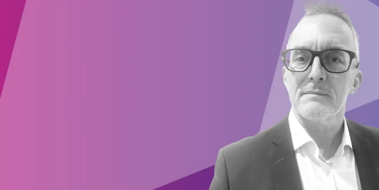 A man wearing glasses and a suit looks forward, positioned on the right side of the image. The background features geometric shapes in shades of purple and pink.