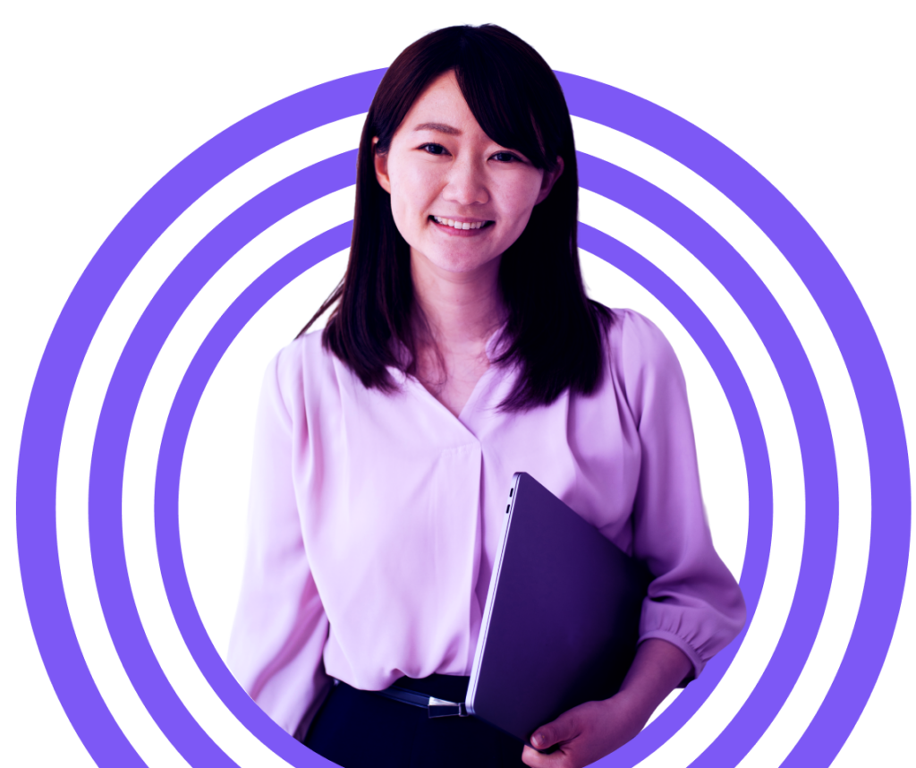 A woman with long dark hair smiles whilst holding a closed laptop, standing in front of concentric purple circles on a light background.