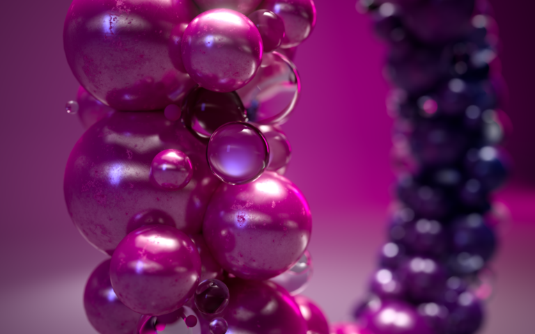 Close-up of glossy, purple and pink spheres clustered together, reflecting light against a blurred magenta background. The arrangement gives a shiny, abstract, and futuristic appearance.