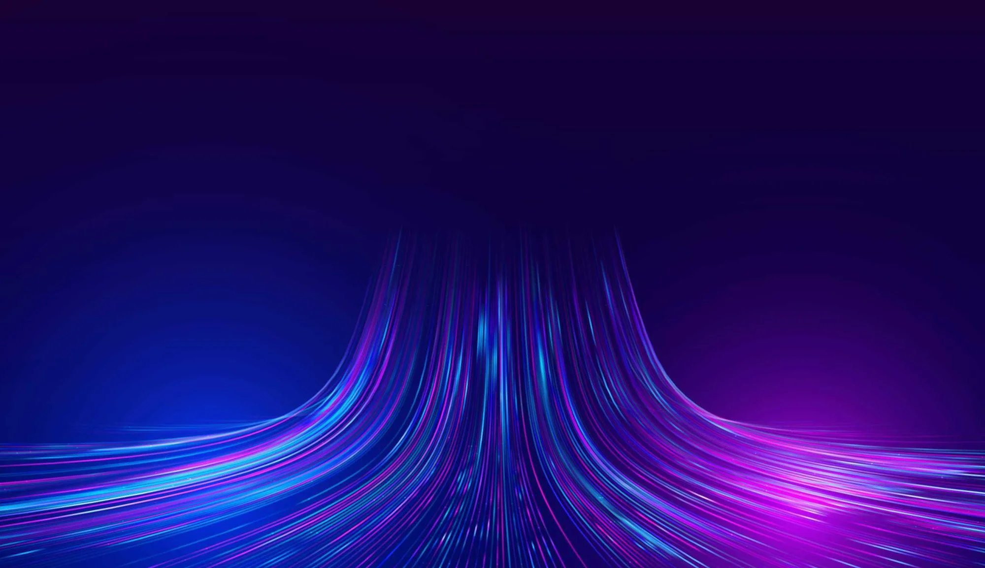 Colourful neon light trails in blue, purple, and pink curve upward on a dark background, creating a futuristic, abstract, and flowing visual effect.