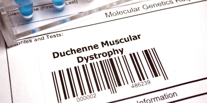 A label with Duchenne Muscular Dystrophy and a barcode is placed on a medical genetic testing form. Test tubes are partially visible at the top left-hand corner.
