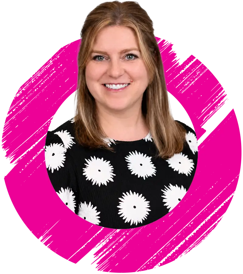 Smiling woman with straight, light brown hair, wearing a black top with white flower patterns. She is pictured inside a pink, roughly drawn circular frame on a white background.