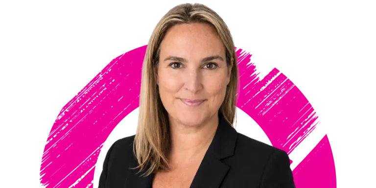 A woman with straight blonde hair, wearing a black blazer, smiles at the camera. The background features a pink brushstroke circle on white.