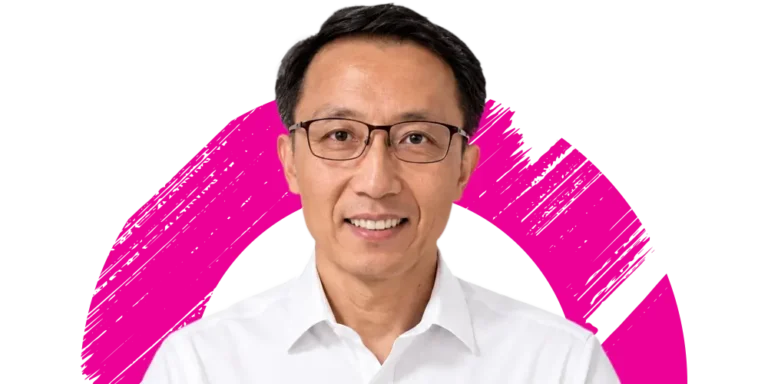 A man with short black hair and glasses, wearing a white shirt, is smiling in front of a white background with a bold pink circular brushstroke design.