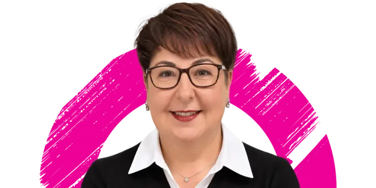 Smiling woman with short brown hair and glasses, wearing a white collared shirt and black jumper, stands in front of a white background with a bold pink circular brushstroke design.