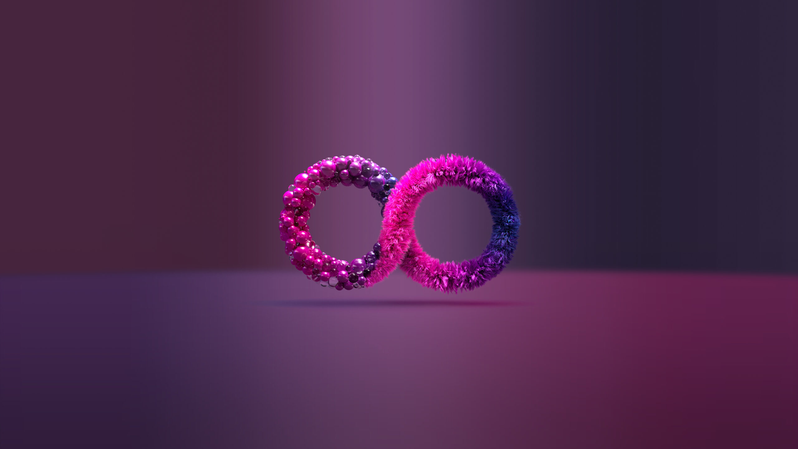 Two textured, glowing rings forming an infinity symbol, with pink and purple hues, float above a softly lit gradient background.
