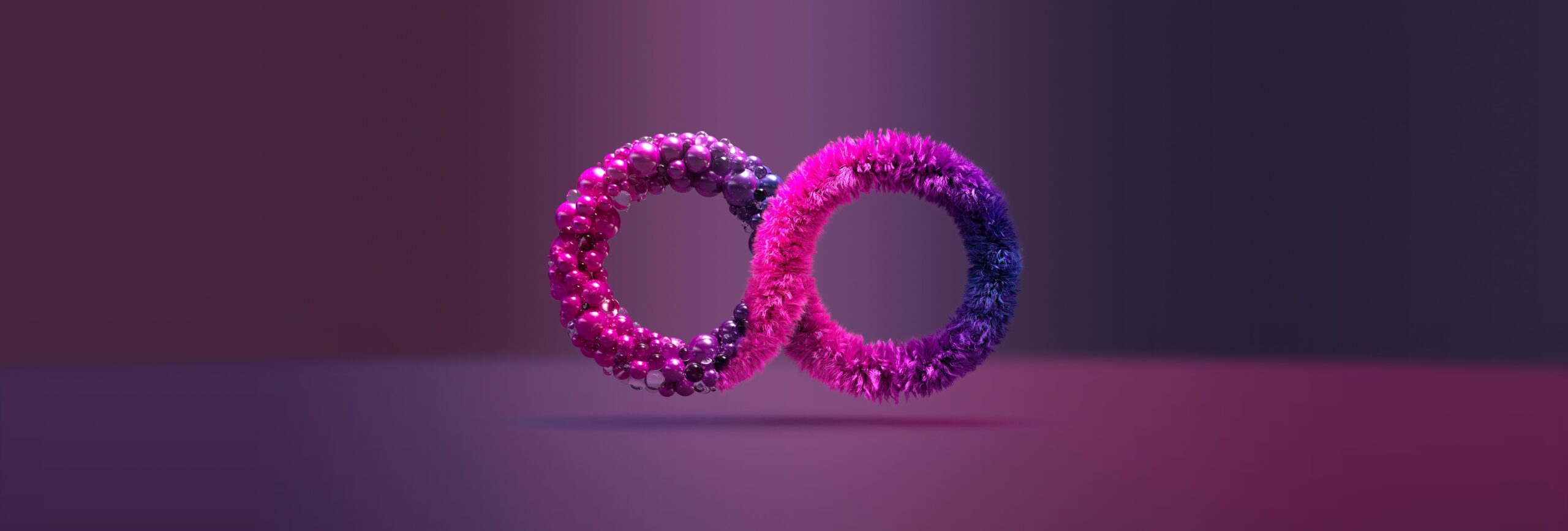 Two textured rings, one pink and sparkly and the other fuzzy and purple, intertwine against a gradient background of dark purple and magenta tones.