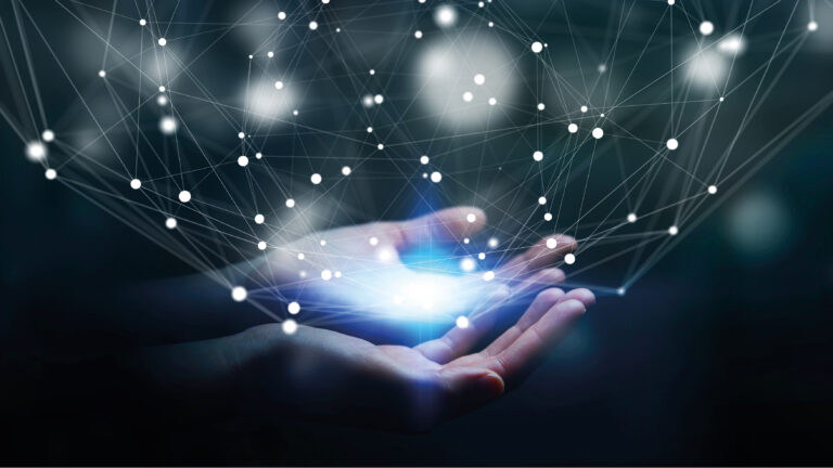 A pair of hands cupping glowing light, with a digital network of interconnected nodes and lines floating above, symbolising technology and connectivity.
