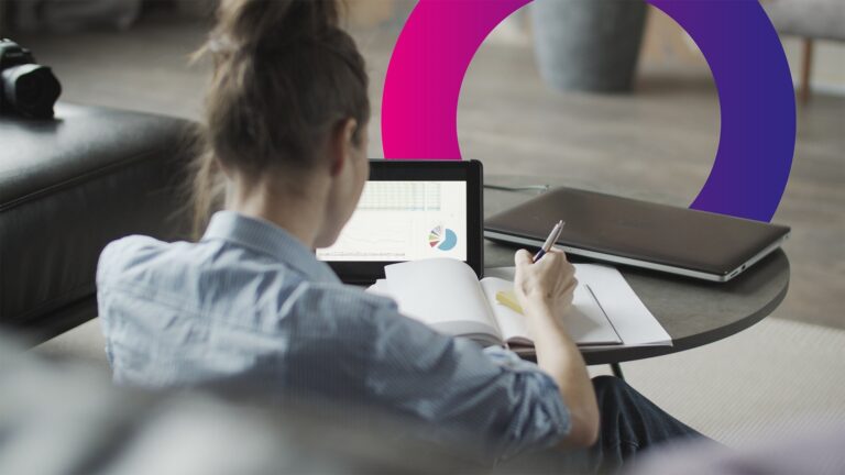 A woman sits at a table, writing in a notebook whilst viewing charts and graphs on a tablet. A laptop is nearby, and colourful circular graphics appear in the background.
