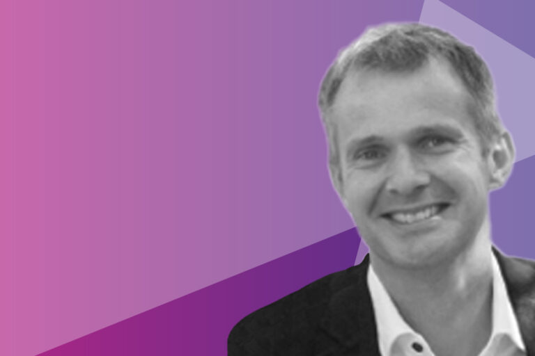 A smiling man in a dark jacket is shown in black and white on the right, with a geometric purple and pink background on the left.