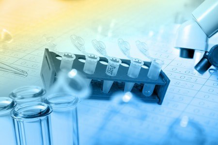Test tubes and vials on a laboratory bench with a microscope in the background, overlaid with scientific data and a blue-yellow gradient light effect.