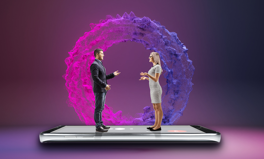 A man and woman stand on a giant mobile phone, facing each other and talking, with a colourful digital ring behind them, symbolising virtual communication.