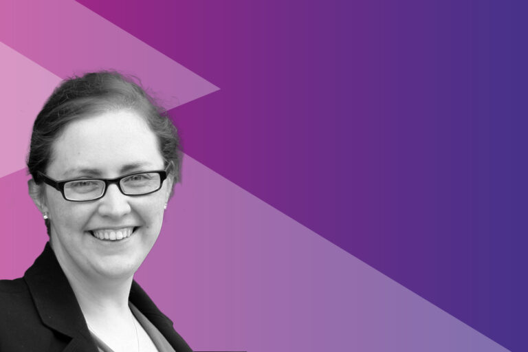 A woman wearing glasses and a blazer smiles at the camera. The background features geometric shapes in shades of purple and pink with plenty of empty space on the right.