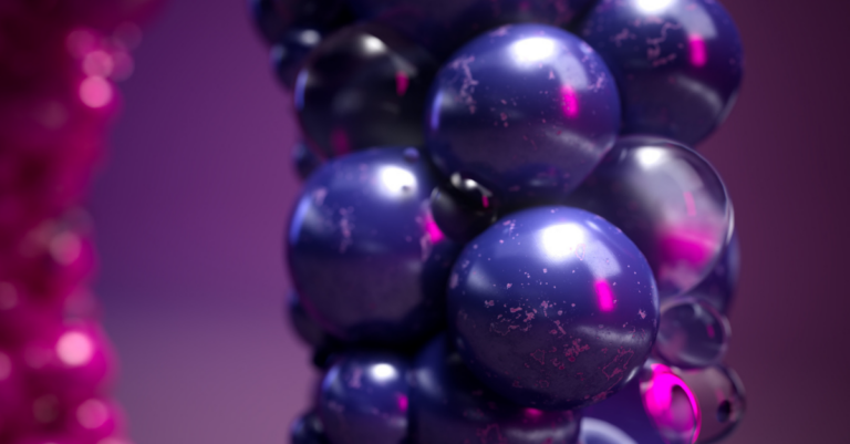 A close-up of glossy, dark purple spheres clustered together, reflecting pink and purple light on a blurred purple background.