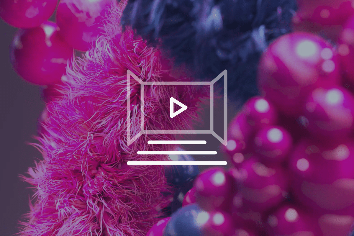 Colourful abstract shapes with pink fuzzy textures and round glossy spheres, featuring a white play icon and lines suggesting a video player interface overlay in the centre.