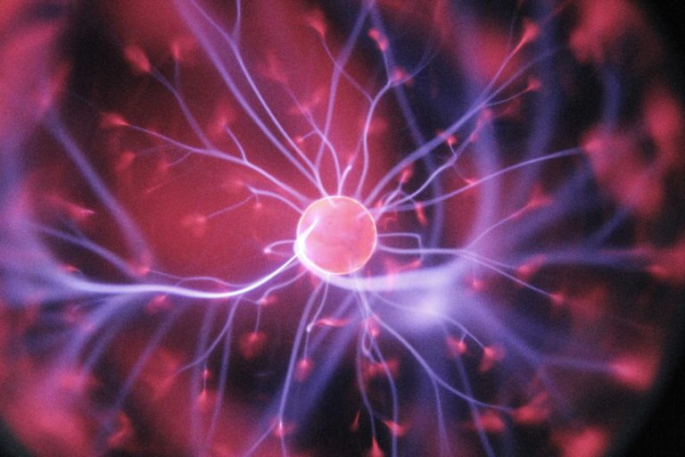 A glowing plasma ball emits purple and pink electric streams from its centre, radiating outward against a dark background.