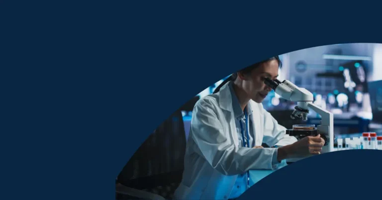 A scientist in a lab coat looks through a microscope, with test tubes and laboratory equipment visible in the background. The image has a blue graphic overlay on the left side.
