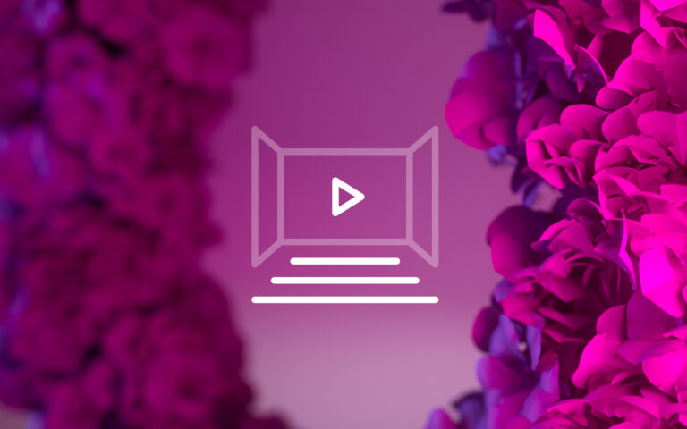 A play button icon is centred over a blurred background with pink and purple flower petals on both sides.