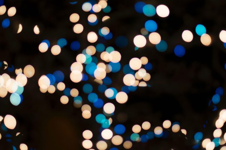 Out-of-focus white and blue lights create a bokeh effect against a dark background.